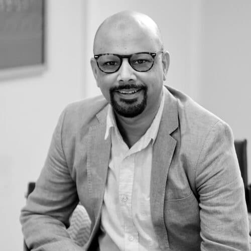 Portrait of Tawhid ar-Rahman, qualified family mediator registered with the Family Mediation Council (FMC) and founder of Salam Mediation, smiling and seated in a professional setting.